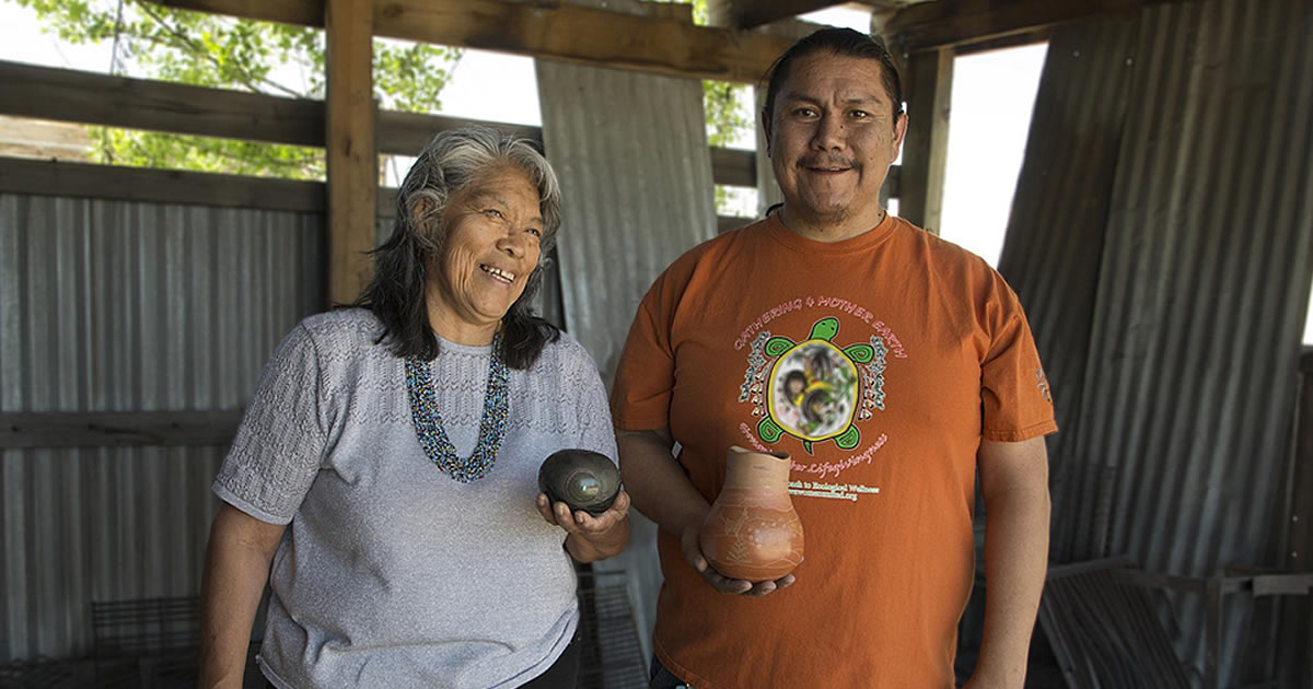 Kathy Wan Povi Sanchez and Wayland Sanchez, in their firing pit in San Ildefonso Pueblo