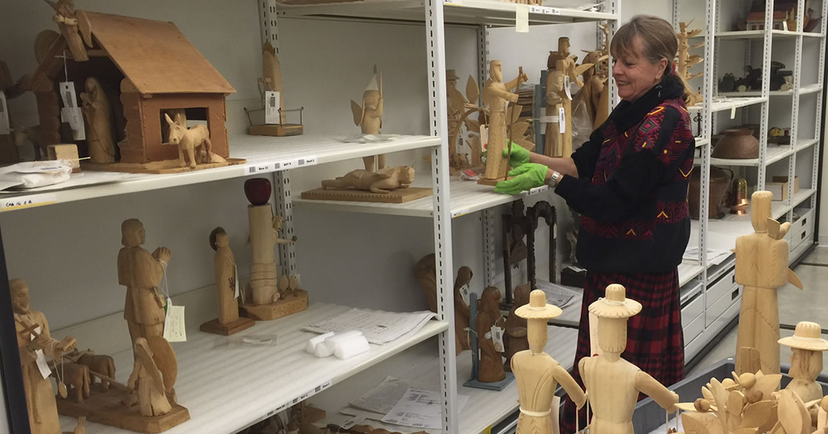 A volunteer moves objects into collections storage.