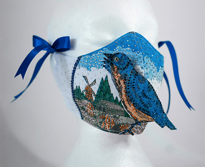 Beaded mask with landscape and blue bird.